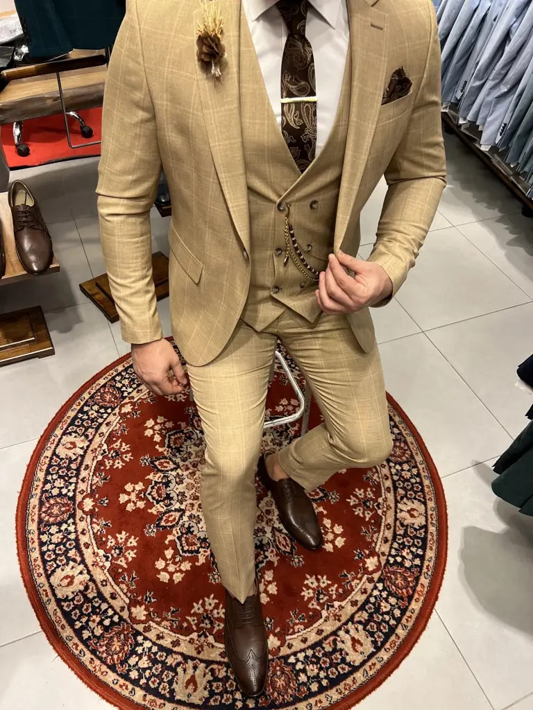 Homme en costume beige élégant sur tapis rouge