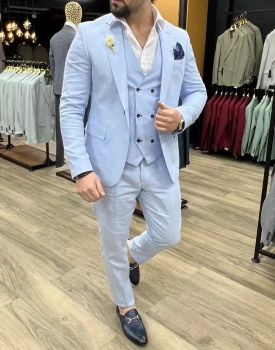 Homme en costume bleu clair élégant dans un magasin