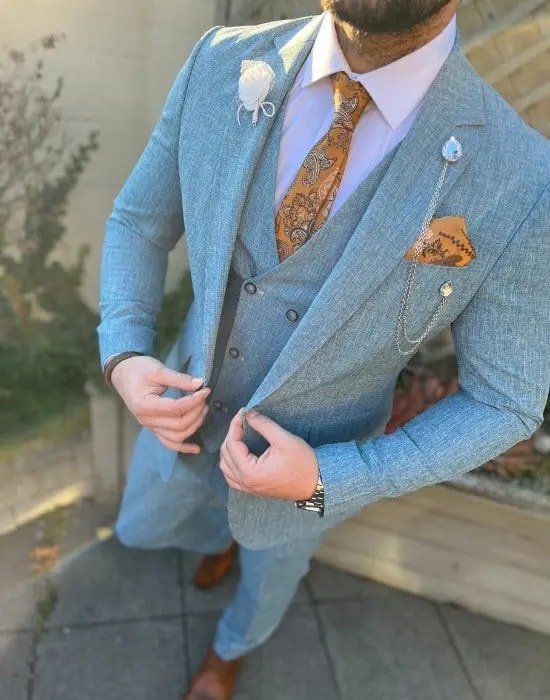 Homme en costume bleu avec cravate et pochette orange