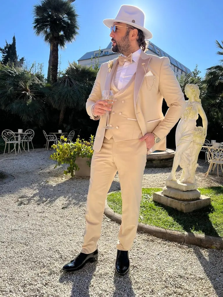 Homme élégant en costume beige avec chapeau blanc