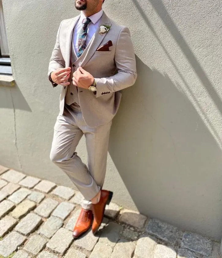 Homme en costume beige avec cravate fleurie et chaussures marron