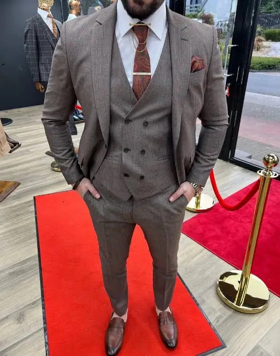Homme en costume marron élégant sur tapis rouge
